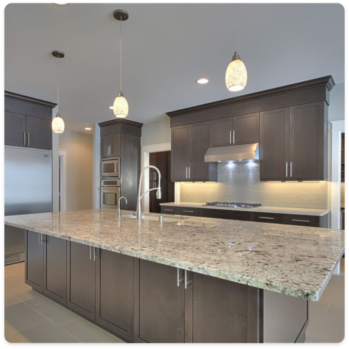 A modern kitchen featuring dark wooden cabinets, stainless steel appliances, and a large granite island with a sink and faucet. Three pendant lights hang above the island, illuminating the space. The sleek design rivals any commercial kitchen, enhanced further by professional interior painting services.